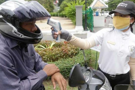 A security guard checks a man’s temperature before he enters a Phnom Penh hotel. The Cambodian health ministry has renewed its calls for the public to follow strict hygiene practices. - The Phnom Penh Post/Asian News Network