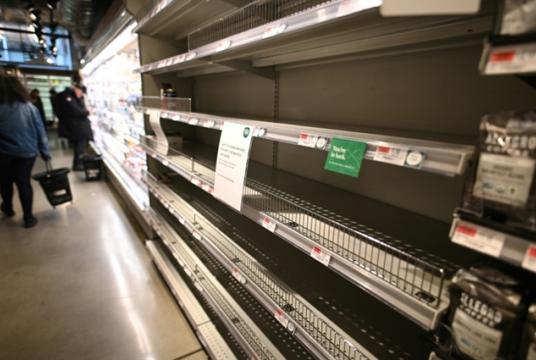 Customers are scrambling to stock up on supplies, leaving empty shelves in many grocery stores, such as this organic supermarket in Manhattan, New York on Friday. — AFP/VNA Photo