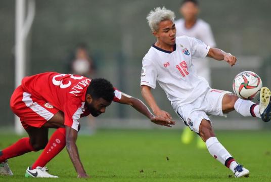 Chanathip Songkrasin, right, battles for the ball with an Omani player.