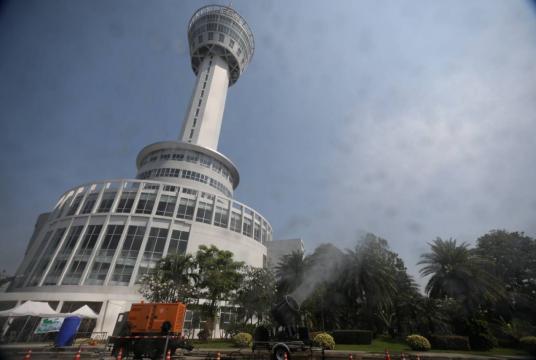 Samut Prakan officials spray water into the air yesterday in a move to remove fine PM2.5 dust |particles yesterday, an exercise that scientists say is pointless./The Nation