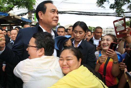Thai Prime Minister Gen Prayut Chan-o-cha is hugged by supporters./The Nation