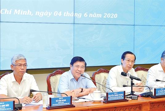 Nguyễn Thành Phong (second from left), chairman of the HCM City People’s Committee, speaks at a meeting held yesterday to review the city’s socio-economic situation in the first five months. —Photo sggp.org.vn