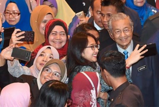 Civil servants crowding around Dr Mahathir to take photographs with him after the gathering in Putrajaya. — Bernama