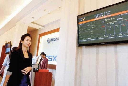 A CSX employee walks in front of a screen displaying the CSX stock price index in 2017./ Heng Chivoan