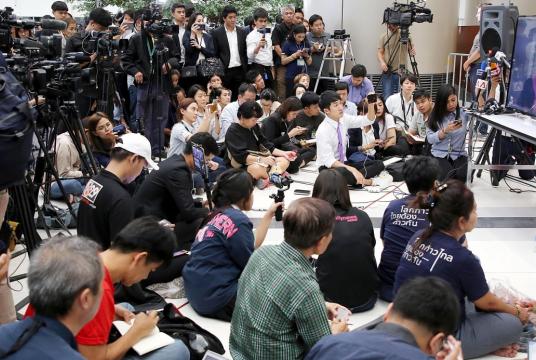 Journalist records a live TV broadcast of a judge delivering the decision of the Constitutional Court in Bangkok to dissolve the Thai Raksa Chart party yesterday.