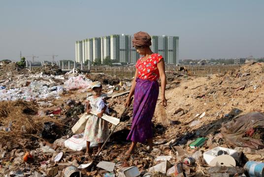 A mother and her daughter earn their living by collecting re-usable materials in the garbage near a luxury residence in South Dagon Township, Yangon (Photo courtesy of Oxfam in Myanmar)