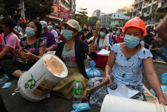 People take part in an anti-coup night protest at Hledan junction in Yangon, on March 14, 2021.PHOTO: REUTERS
