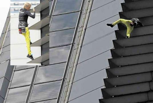 A French urban climber Alain Robert hangs precariously as he deftly climbs with his bare hands the 47-story GT International Tower on Ayala Avenue, Makati City, before noon on Tuesday, leaving people below awestruck. As in his previous capers in other countries, the 56-year-old French ‘Spider-Man’ was later held for public disturbance. —LYN RILLON