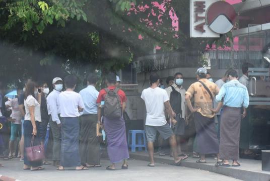 People queue up for their turn at the ATM.