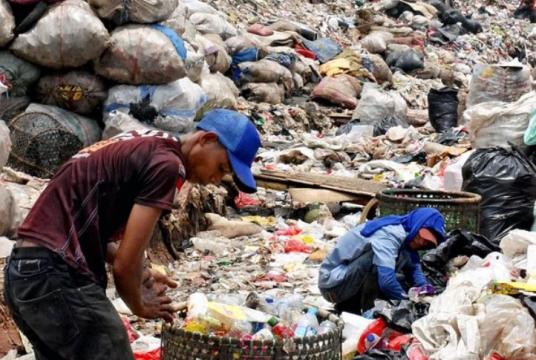 People collect plastic bottles and other recyclable waste at a garbage disposal site in Bantar Gebang in the suburbs of Jakarta./The Japan News