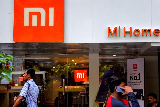 Pedestrians walk past a Mi home mobile store in Kolkata, India. [Photo provided to China Daily]