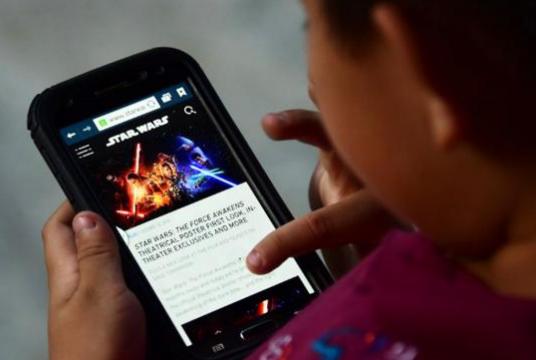 A child is using a smartphone. AFP file photo
