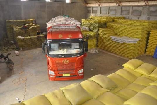 Bags of rice being loaded onto a Chinese cargo truck at Muse  