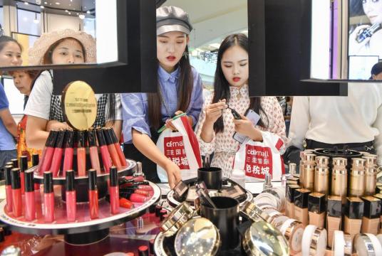 Customers check out cosmetics at a duty-free shop in Sanya, Hainan province. (Photo by Luo Yunfei/China News Service)