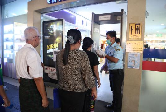 People line up to take their temperature at Capital Supermarket in Thakayta Township