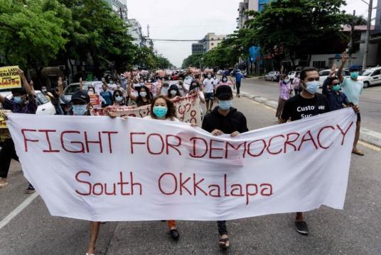 Protesters march with a banner during a demonstration against the military coup in Yangon, on April 30, 2021.PHOTO: AFP