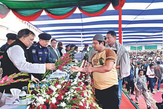 Home Minister Asaduzzaman Khan Kamal hands out flowers to a listed drug trader during a surrender ceremony yesterday morning on the premises of Teknaf Model Primary School in Cox's Bazar. Over 100 known yaba godfathers and dealers surrendered and vowed to shun the path