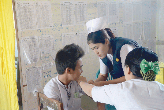 A nurse from Health Department injects measles and vaccine to a student. (Photo-Kyi Naing)