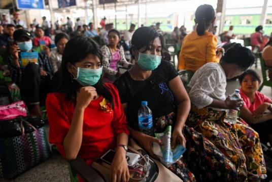 People wear face masks as a preventive measure against the Covid-19 coronavirus while waiting for a ride at the central railway station in Yangon, Myanmar, on March 19, 2020.PHOTO: AFP
