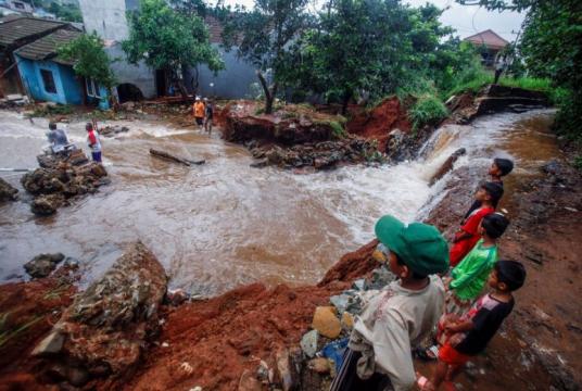 People gather around a dam which collapsed after heavy rains in West Java, on Jan 2, 2020.PHOTO: REUTERS/ANTARA FOTO