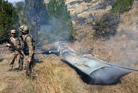 Pakistani soldiers stand next to what Pakistan says is the wreckage of an Indian fighter jet shot down in PoK in Bhimbar district near the LoC on February 27, 2019. (Photo: AFP)