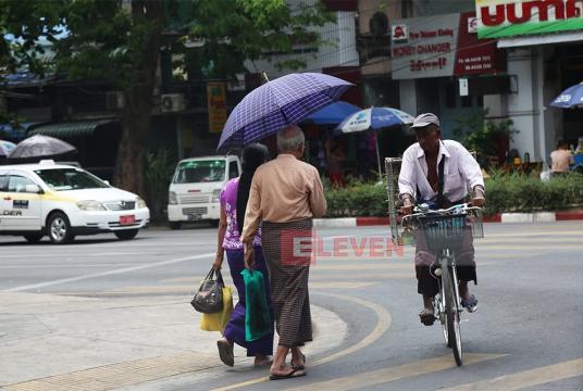 People seen traveling during the daytime heat in Yangon. (Photo: Kyi Naing)