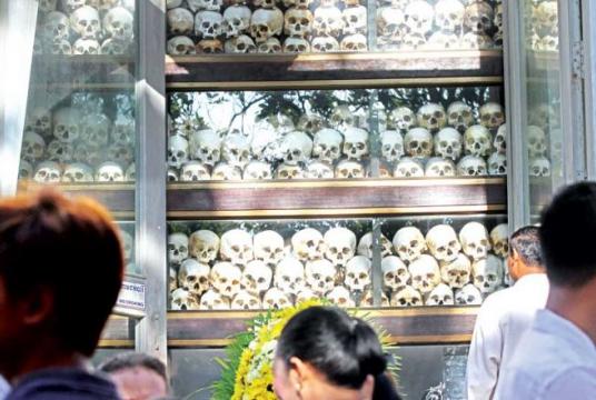 n an event to commemorate the National Day of Rememberance on Monday, participants pay their respects at a stupa containing skulls of the victims of the Khmer Rouge at the Choeung Ek Killing Field. Heng Chivoan
