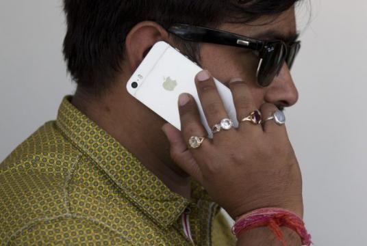 An Indian man talks on his iPhone in New Delhi, India, Wednesday, May 18, 2016. (AP Photo/Tsering Topgyal)