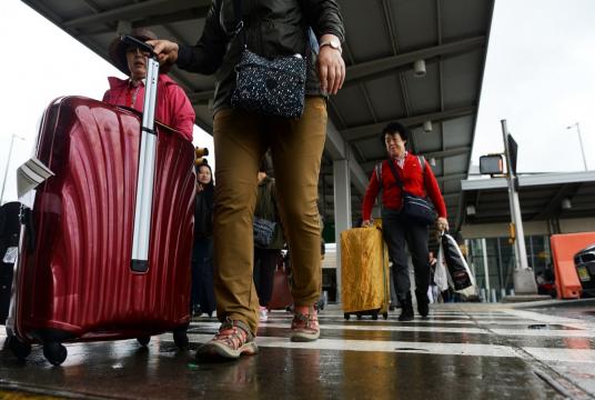Arriving passengers make their way from Terminal 4 at the JFK airport in New York on October 11, 2014. US authorities have said they would start screening at three airports to detect travelers arriving via direct or connecting flights from Wuhan who may have symptoms of the new virus. (AFP/Jewel Samad)