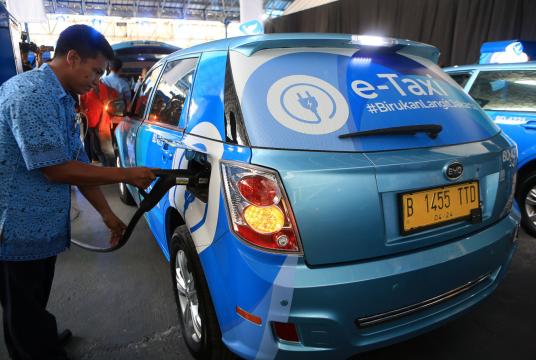 A driver plugs in a Blue Bird e-taxi during the debut of the company's e-taxis in Jakarta on April 22. (JP/Seto Wardhana) 