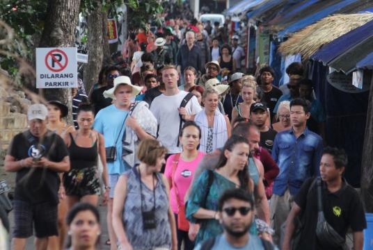Tourists walk to a pick-up point on Sanur Beach, Denpasar after their return from Nusa Penida Island in Bali on Monday. (JP/Zul Trio Anggono)