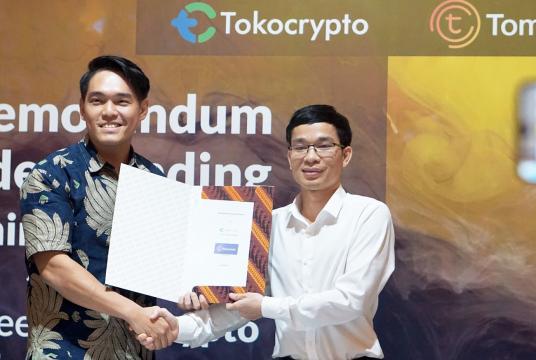Tokocrypto CEO Pang Xue Kai (left) and TomoChain CTO Son Nguyen show document after they signed a cooperation agreement in Jakarta on March 28. (Courtesy of/Tokocrypto)