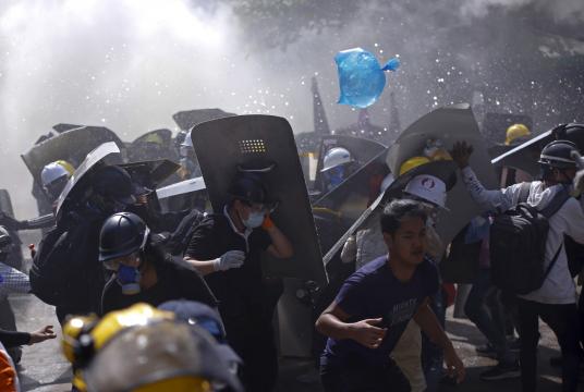 Protesters are dispersed as riot police fire tear gas during a demonstration in Yangon, Myanmar, March 8, 2021. (AP-Yonhap)