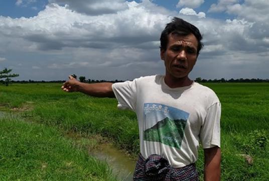 A local farmer points to the military-seized land in Khin-U Township
