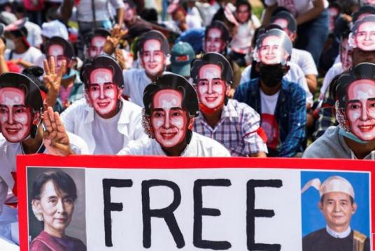 Protesters wearing masks depicting ousted leader Aung San Suu Kyi, flash three-finger salutes as they take part in a protest against the military coup in Yangon, Myanmar, February 28, 2021. Reuters