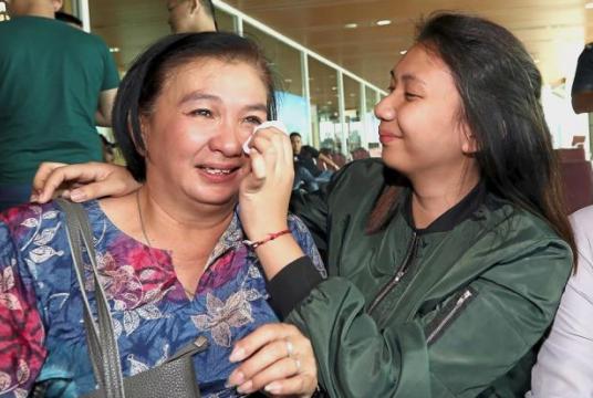 Overwhelmed: Julie Lala Jubang (left) and her daughter Brenda Weltinnie Winston shedding tears as they hug each other at Kuching International Airport./The Star