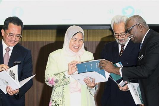 Towards better rules: Zuraida﻿ flipping through a copy of the new National Housing Policy ﻿during its launch at the Nat Sime Darby Convention Centre. Looking on are﻿ (from left) Housing and Local Government Ministry sec﻿-gen﻿ Datuk Seri Mohammad Mentek, Deputy Housing and Local Government Minister Datuk Raja Kamarul Bahrin Shah and National Housing Department director-general N.Jayaselan﻿./The Star