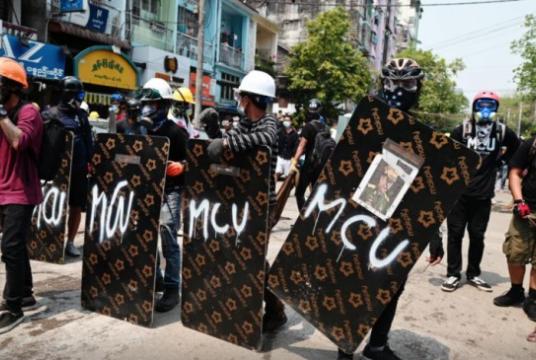 Demonstrators stand behind makeshift shields during an anti-coup protest in Yangon, Myanmar, on March 12, 2021. Photo: Reuters/ Stringer