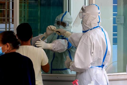 Health workers taking swabs from a returnee to Yangon Region. (Photo-Thiha Aung)  