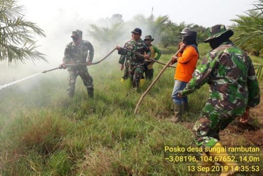 Military personel help ground firefighters in South Sumatra to douse raging fires.PHOTO: INDONESIA DISASTER MANAGEMENT AGENCY (BNPB)