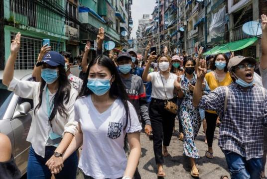 Protesters make the three-finger salute during a demonstration in Yangon on April 27, 2021.PHOTO: AFP
