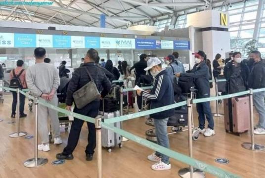 Myanmar citizens seen checking in at an airport in Japan before departure for their home country.   