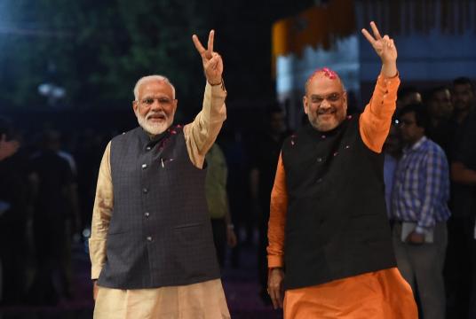 Prime Minister Narendra Modi (L) and president of the ruling Bharatiya Janata Party (BJP) Amit Shah gesture as they celebrate the victory in India's general elections, in New Delhi on May 23, 2019. (Photo by Money SHARMA / AFP)