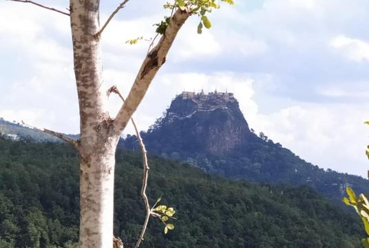 The photo shows a distant view of Papa Taungkalat. 