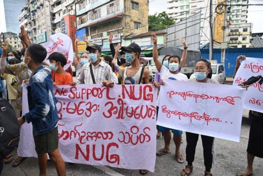 Protesters hold a banner supporting the National Unity Government during a demonstration in Yangon on July 11, 2021.PHOTO: AFP