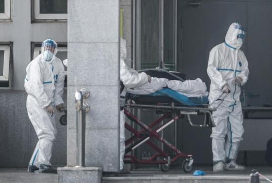 Medical staff members carry a patient into the Jinyintan hospital, where patients infected by Coronavirus are being treated, in Wuhan in China's central Hubei province. (File Photo: AFP)
