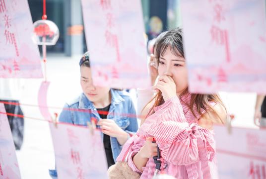 A girl reads a poster at a matchmaking event held by Alibaba Group at its headquarters in Hangzhou, Zhejiang province. There are more than 240 million singles in China, which has spawned a booming singles economy. [Niu Jing/for China Daily]