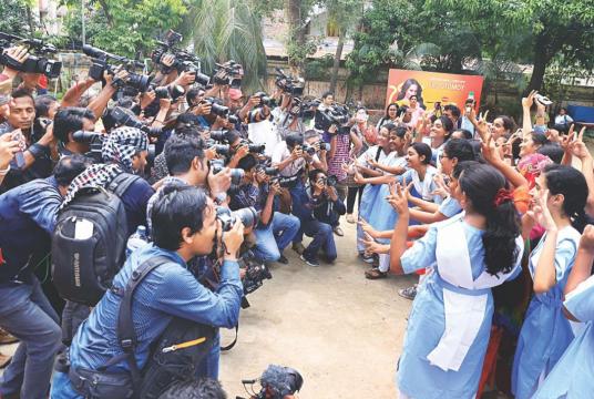 Gleeful students flash the victory sign to photographers who flocked to Viqarunnisa Noon School and College in the capital after the SSC results were published yesterday. Photo: Amran Hossain