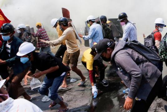 Tear gas and fire extinguisher gas surround demonstrators as they run away from police during a protest against the military coup in Naypyitaw, Myanmar, on March 8, 2021.PHOTO: REUTERS