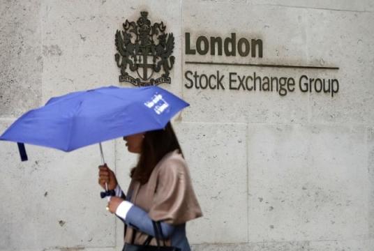 Commuters walk past the London Stock Exchange in the City of London on Aug 9, 2017. The Hong Kong stock exchange says it has started talks to buy the London Stock Exchange that would value the British company at 29.6 billion pounds (US$36.6 billion). (TOLGA AKMEN / AFP)